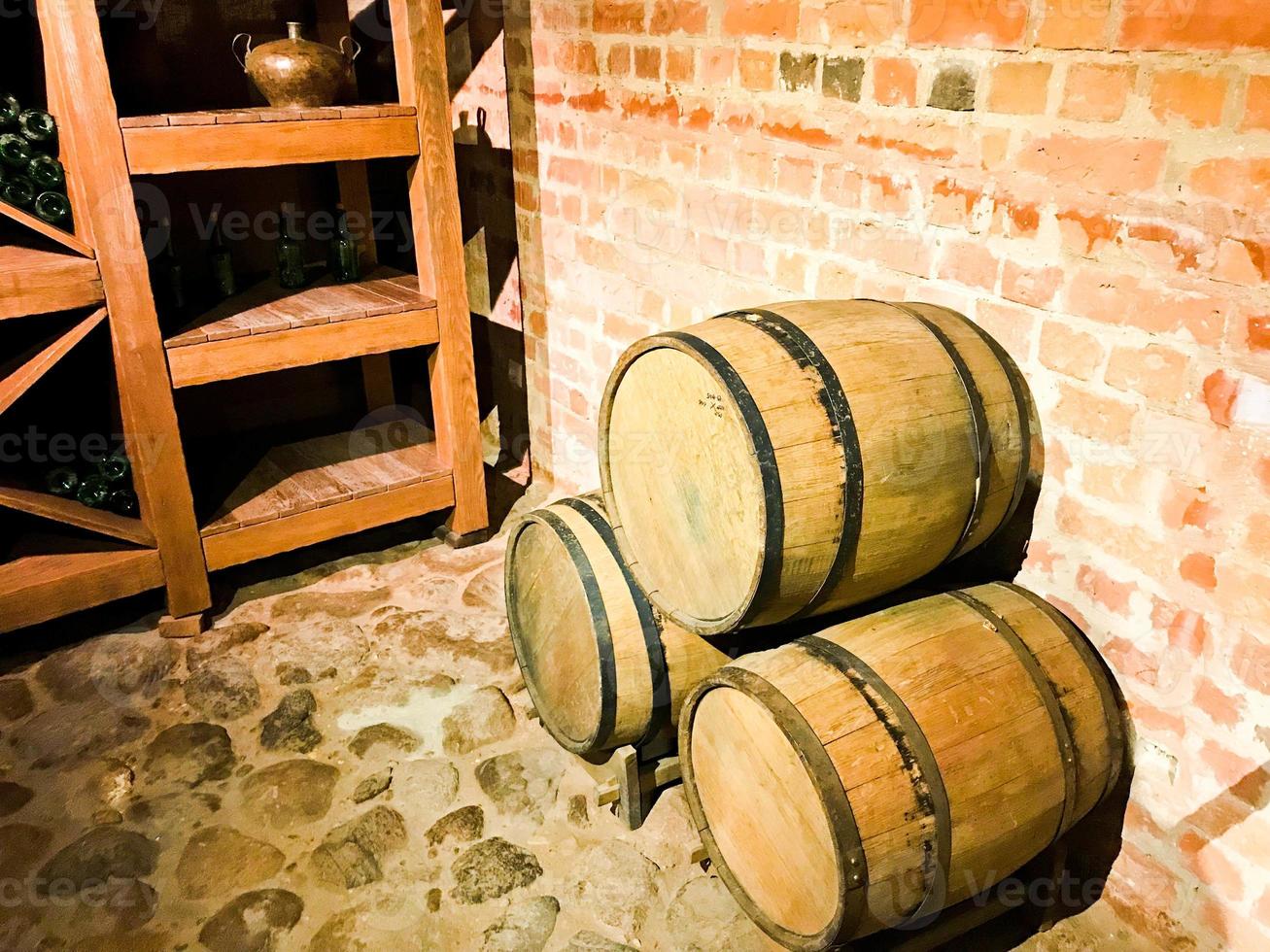 grandes barriles redondos de madera para cerveza, vino en la antigua bodega de la edad media hecha de ladrillo foto