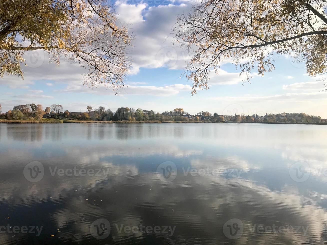 Autumn landscape beautiful with trees and yellow leaves on the lake against the blue sky on a sunny day photo