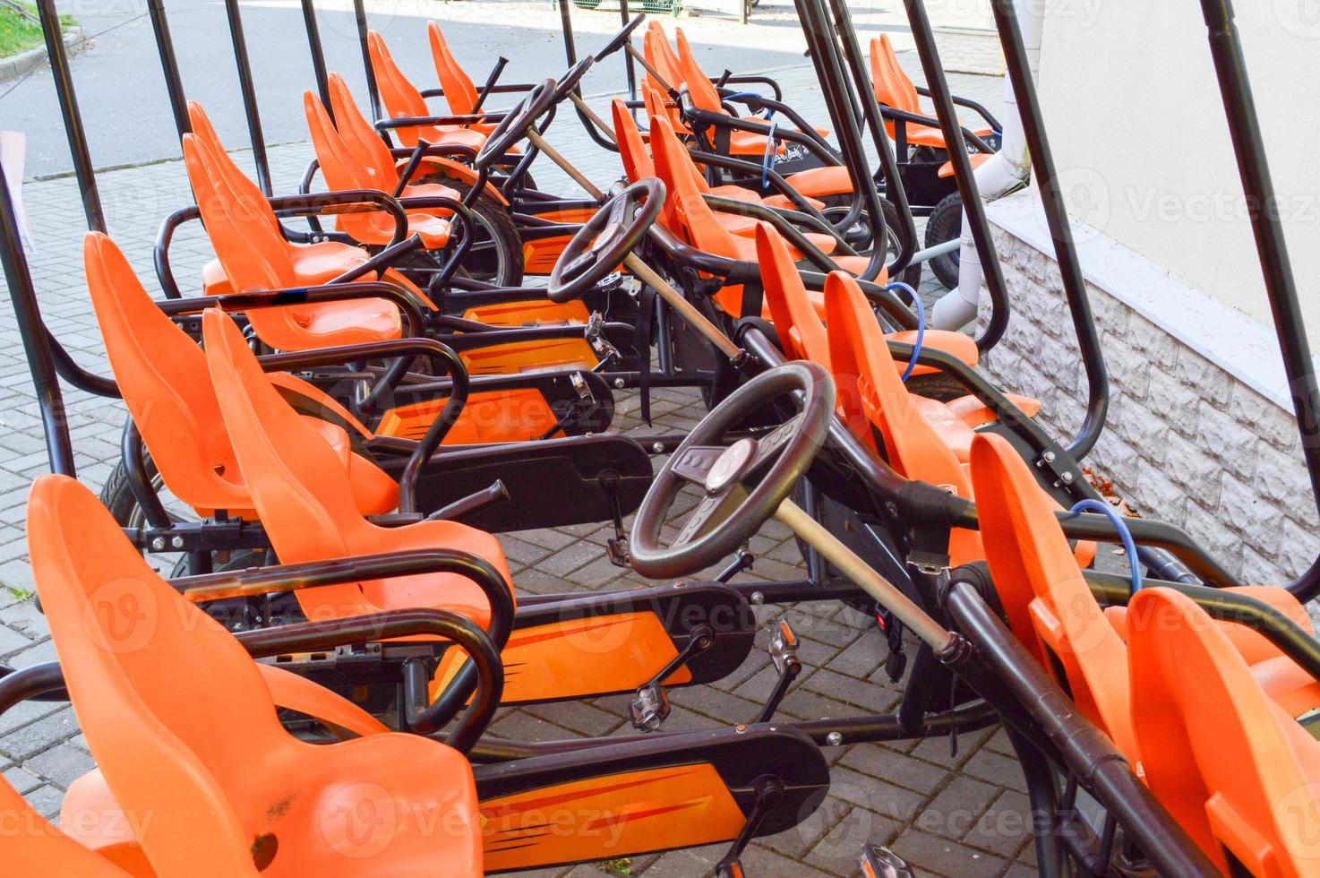 Many fashionable orange four-wheeled sports bicycles, cycle cards for family sports recreation and tourism with a wheel and pedals parked in the autumn park photo