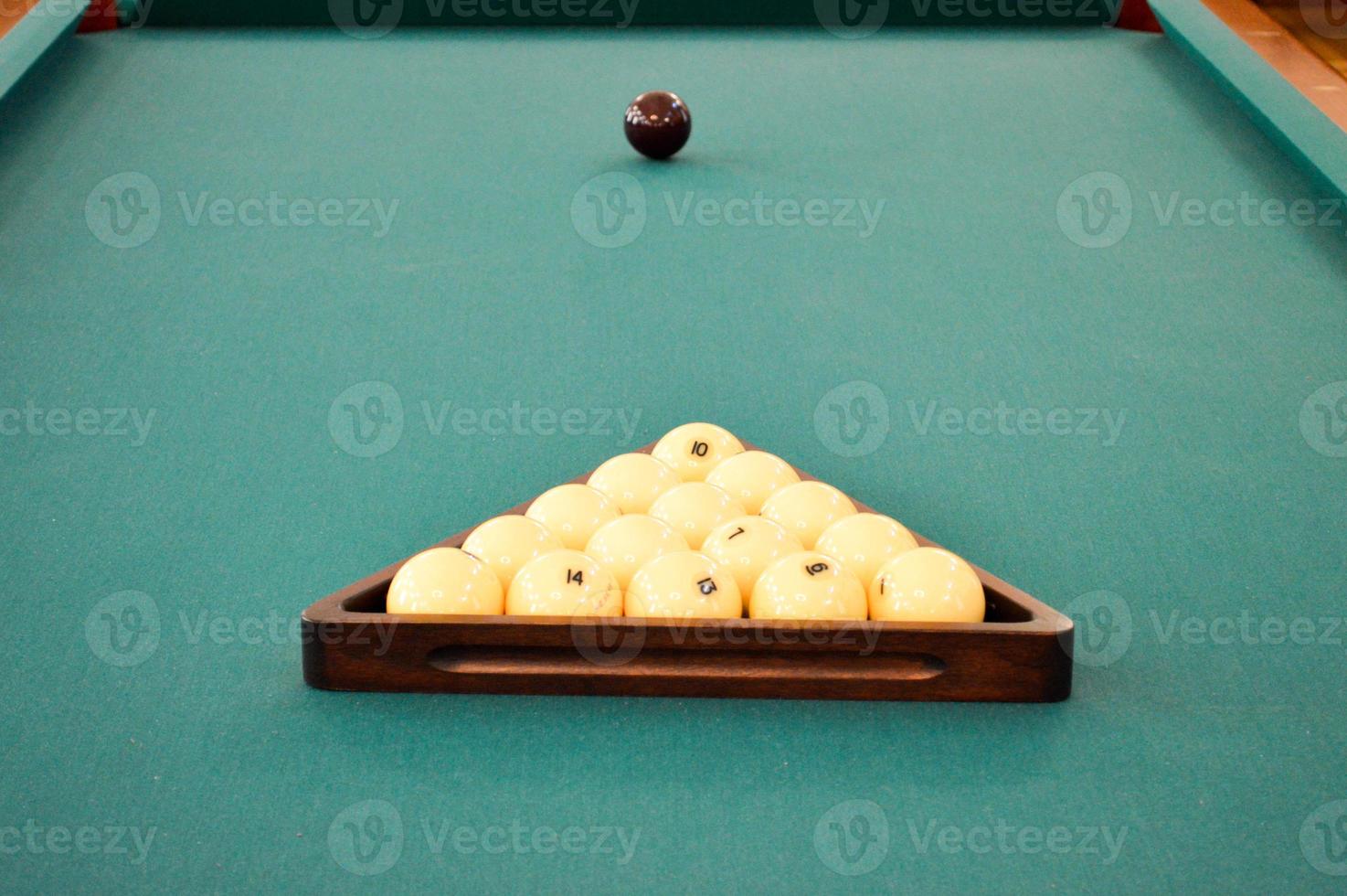 mesa de deportes de billar verde con billar, una piscina con una bola blanca y negra y un triángulo foto