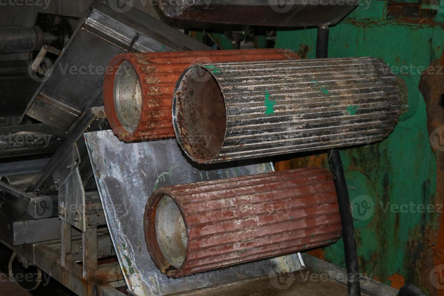 Large metal rollers rolls with teeth of the gears of the production line, a conveyor belt in the workshop at an industrial chemical petrochemical machine-building refinery with equipment machines photo