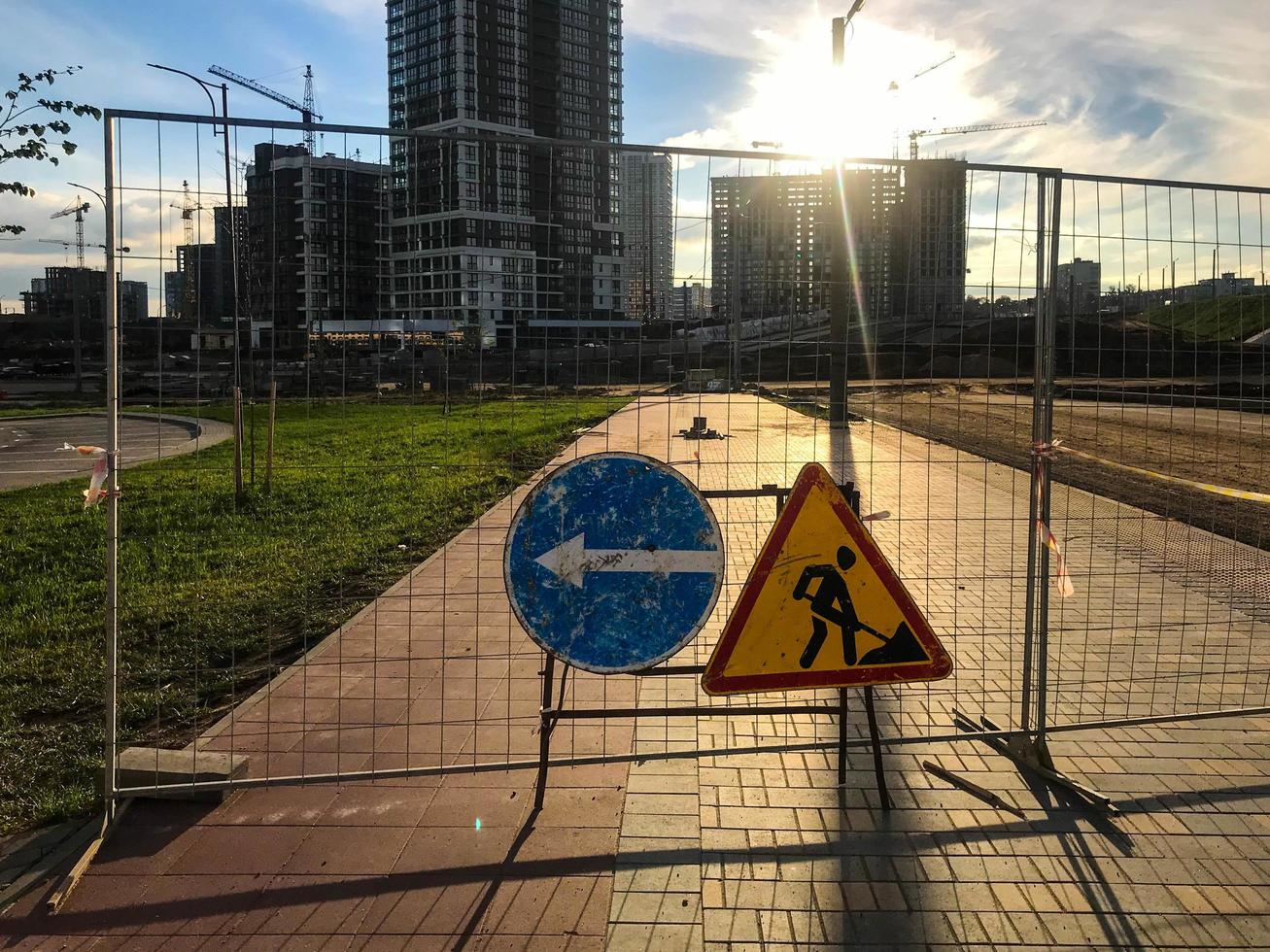 road signs are on dangerous sections of the road. construction site, build new houses and a multifunctional complex. the pedestrian passage is closed. detour on the left. renovation photo