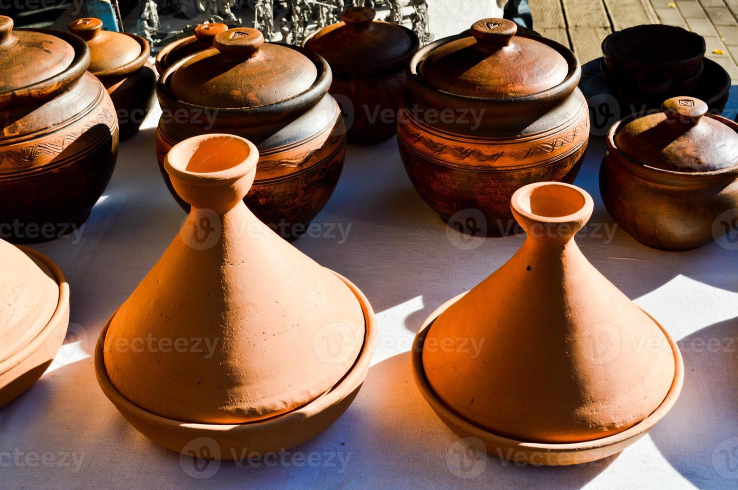 Natural traditional clay pottery beautiful old kitchen appliances, dishes, jugs, vases, pots, mugs. The background photo