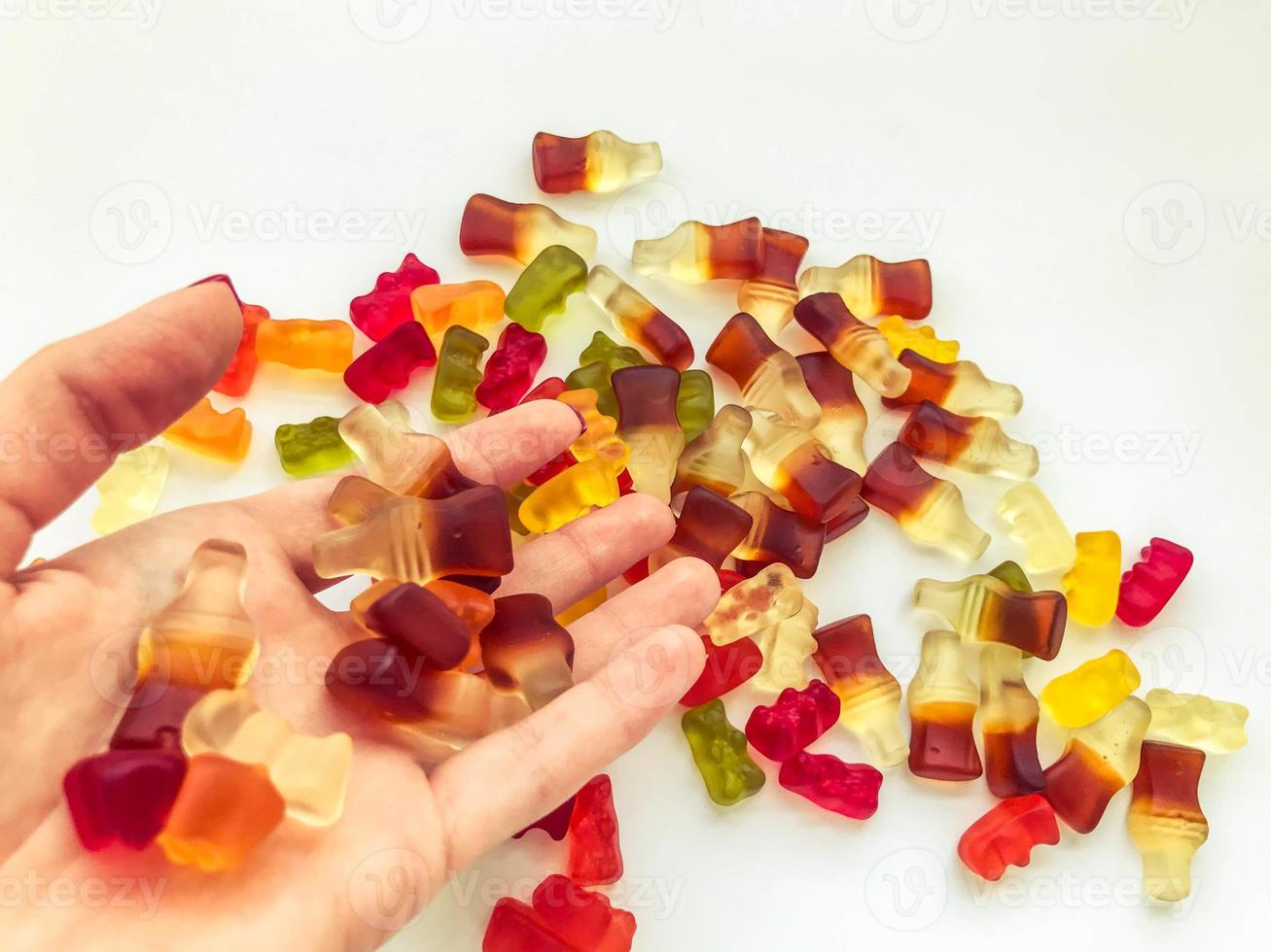 bright, tasty, unusual gummies made from gelatin of various shapes. appetizing sweets on hand. girl preparing dessert for a party. colored gummies from nectar and juices photo