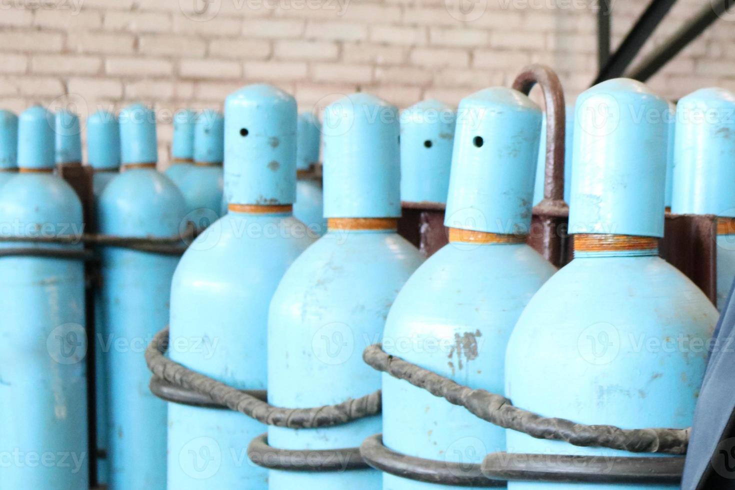 Large iron metal blue gas cylinders with oxygen, air, helium under excessive internal pressure to store compressed, liquefied and dissolved under pressure gases photo