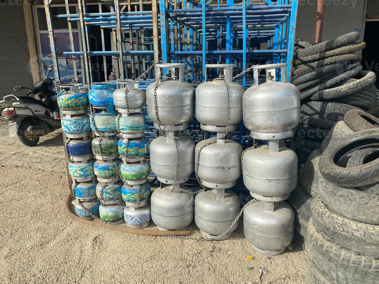 Iron metal cylinders for storing liquefied gas for cooking and industrial stand in a row with a wall in an industrial warehouse photo
