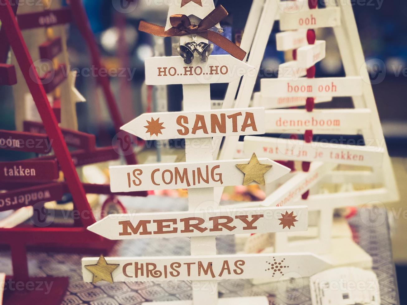 Wooden beautiful toy decorative Christmas cute festive Christmas trees with inscriptions of happy Christmas, Santa is coming. The background photo