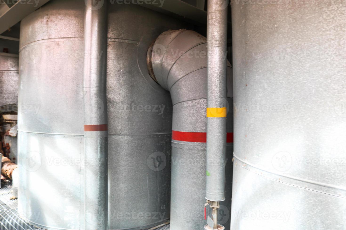 Large iron heat exchanger, tank, reactor, distillation column in thermal insulation of fiberglass and mineral wool of galvanized steel in the industrial refinery petrochemical plant shop photo