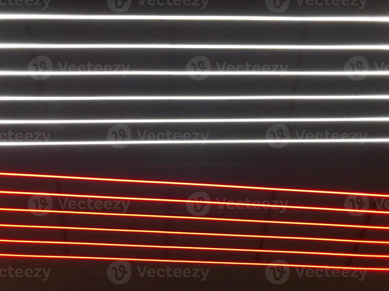 Abstract festive vertical background with red, orange and white LED stripes on a black background for design on the theme of Christmas, New Year, disco style, EDM photo