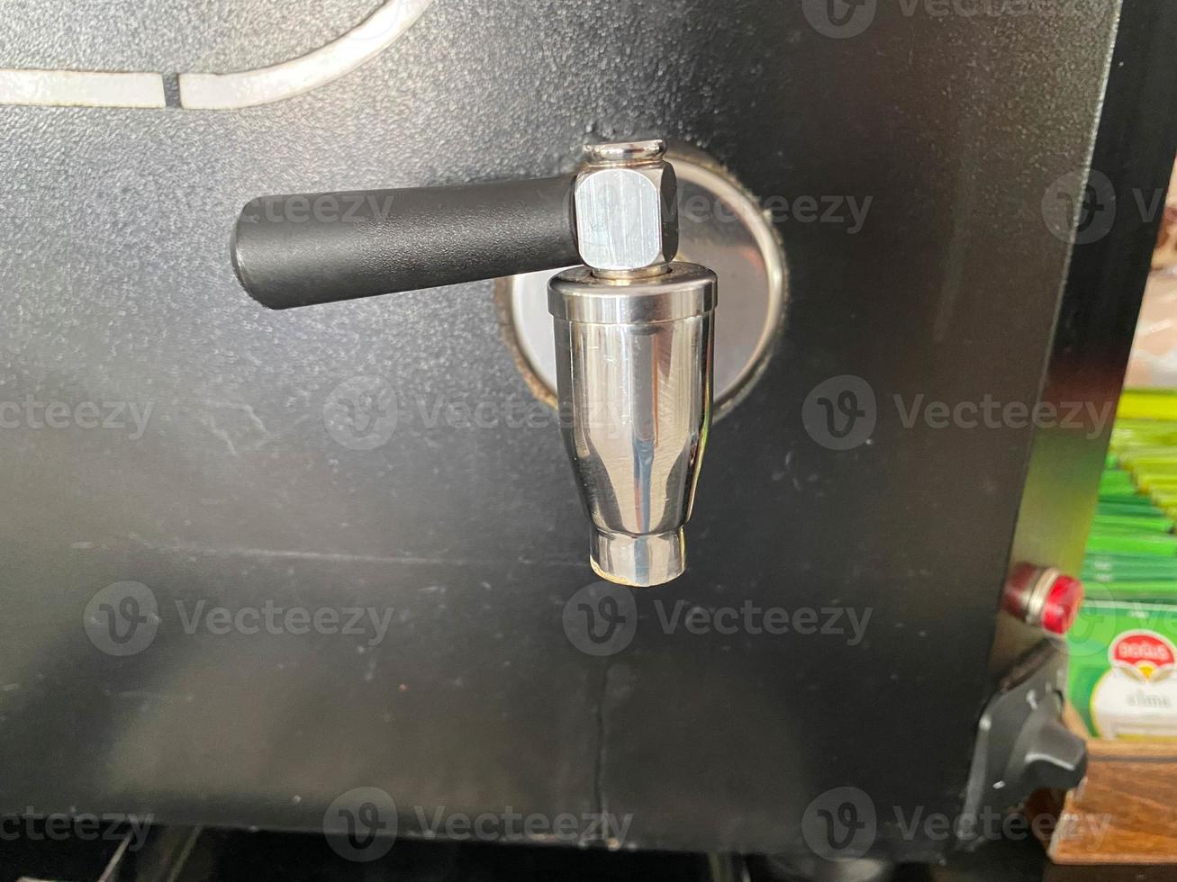 Shiny metal taps and tubes for pouring coffee from a coffee machine. Apparatus for hot drinks photo
