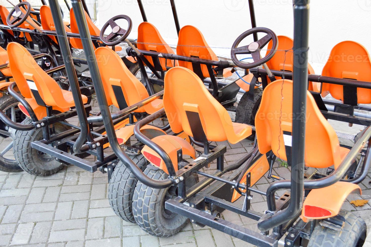 Many fashionable orange four-wheeled sports bicycles, cycle cards for family sports recreation and tourism with a wheel and pedals parked in the autumn park photo