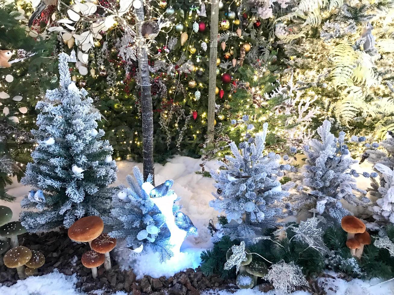 new year cute decorations for the shopping center. artificial Christmas trees with lights, garlands and decorations. under the fir trees, handmade mushrooms photo