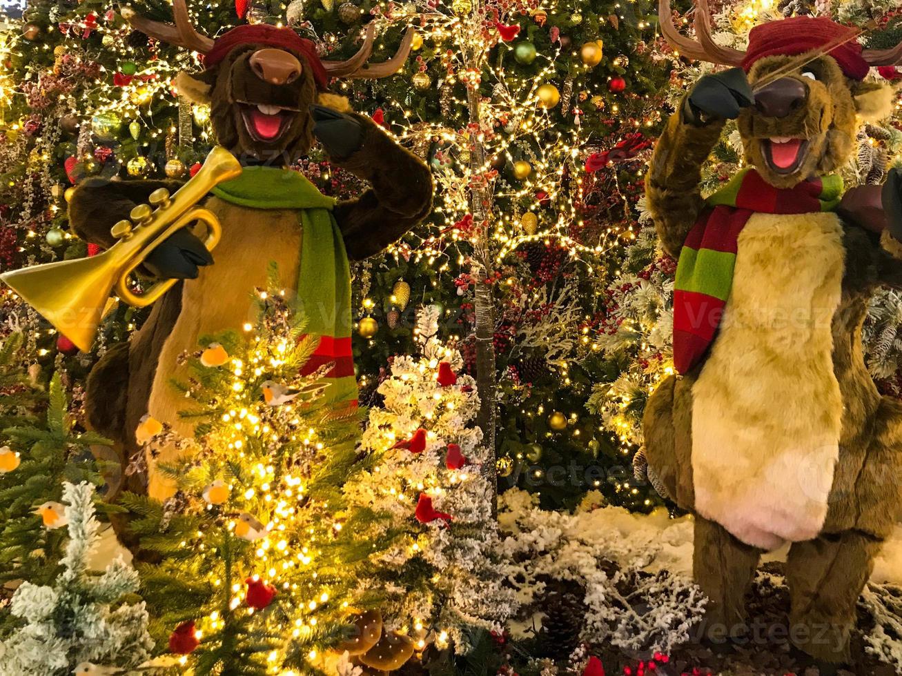 Christmas Eve. there are tall toy deer in the mall. deer play music on the saxophone. entertainment for visitors to the shopping center. deer in cute scarves photo