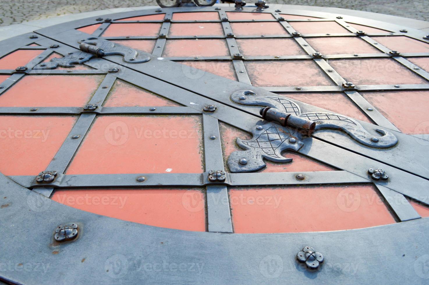 textura de una antigua puerta de metal de hierro resistente rojo antiguo medieval con remaches y patrones de clavos. el fondo foto