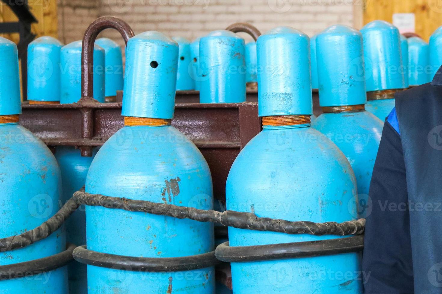 Large iron metal blue gas cylinders with oxygen, air, helium under excessive internal pressure to store compressed, liquefied and dissolved under pressure gases photo