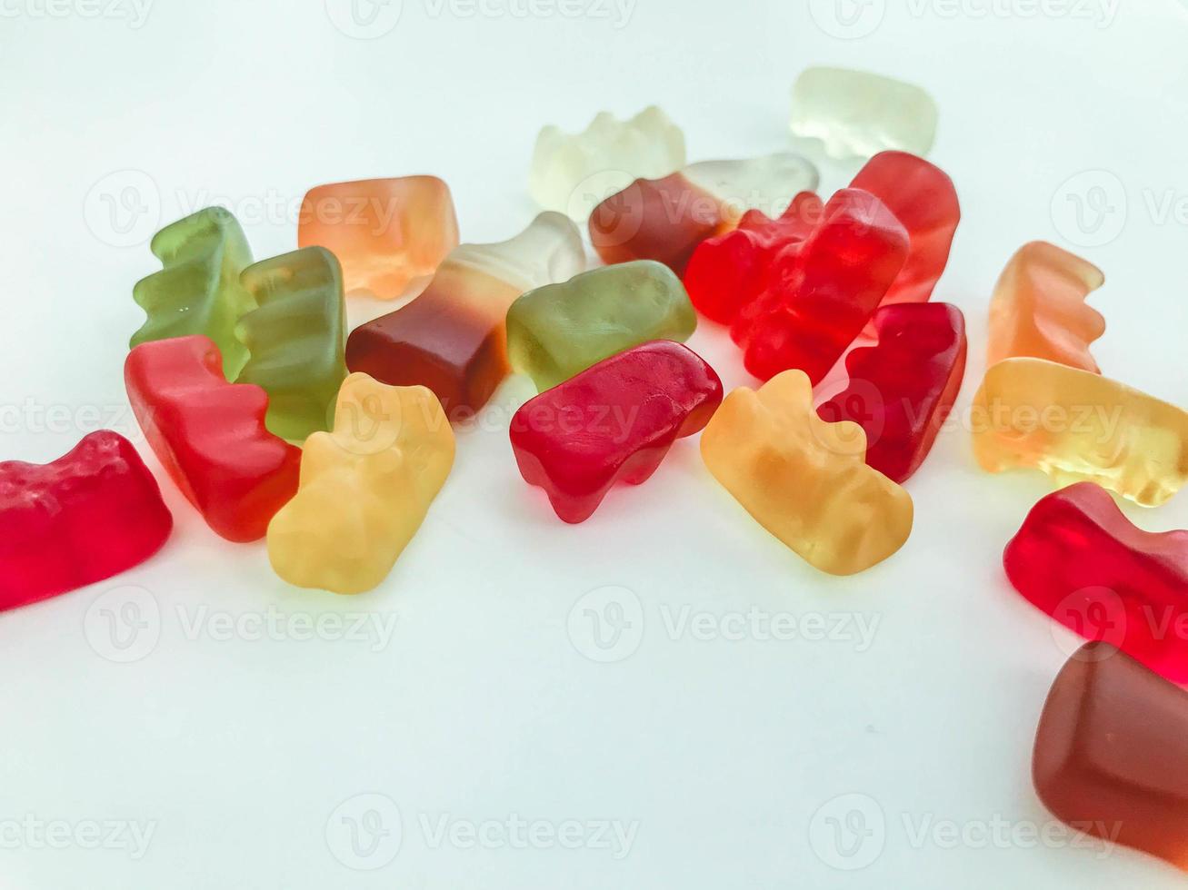 gummy candy on a white matte background. marmalade in the form of gelatinous bears lies on the table. mouth-watering sweet candies for kids and adults photo