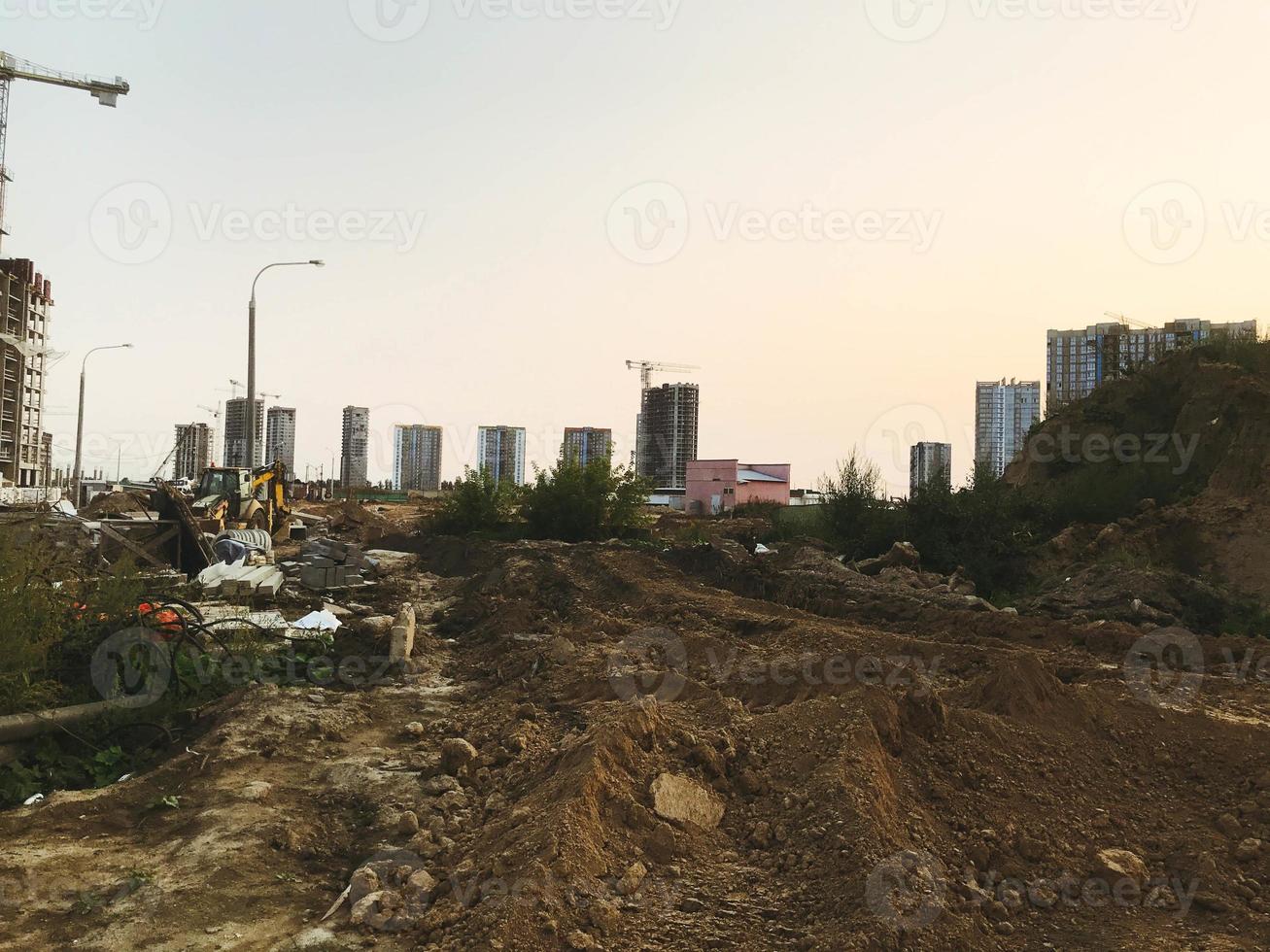 construction site. sand embankment. a lot of sand and building materials for the construction of houses. the construction site is fenced with a long metal fence photo