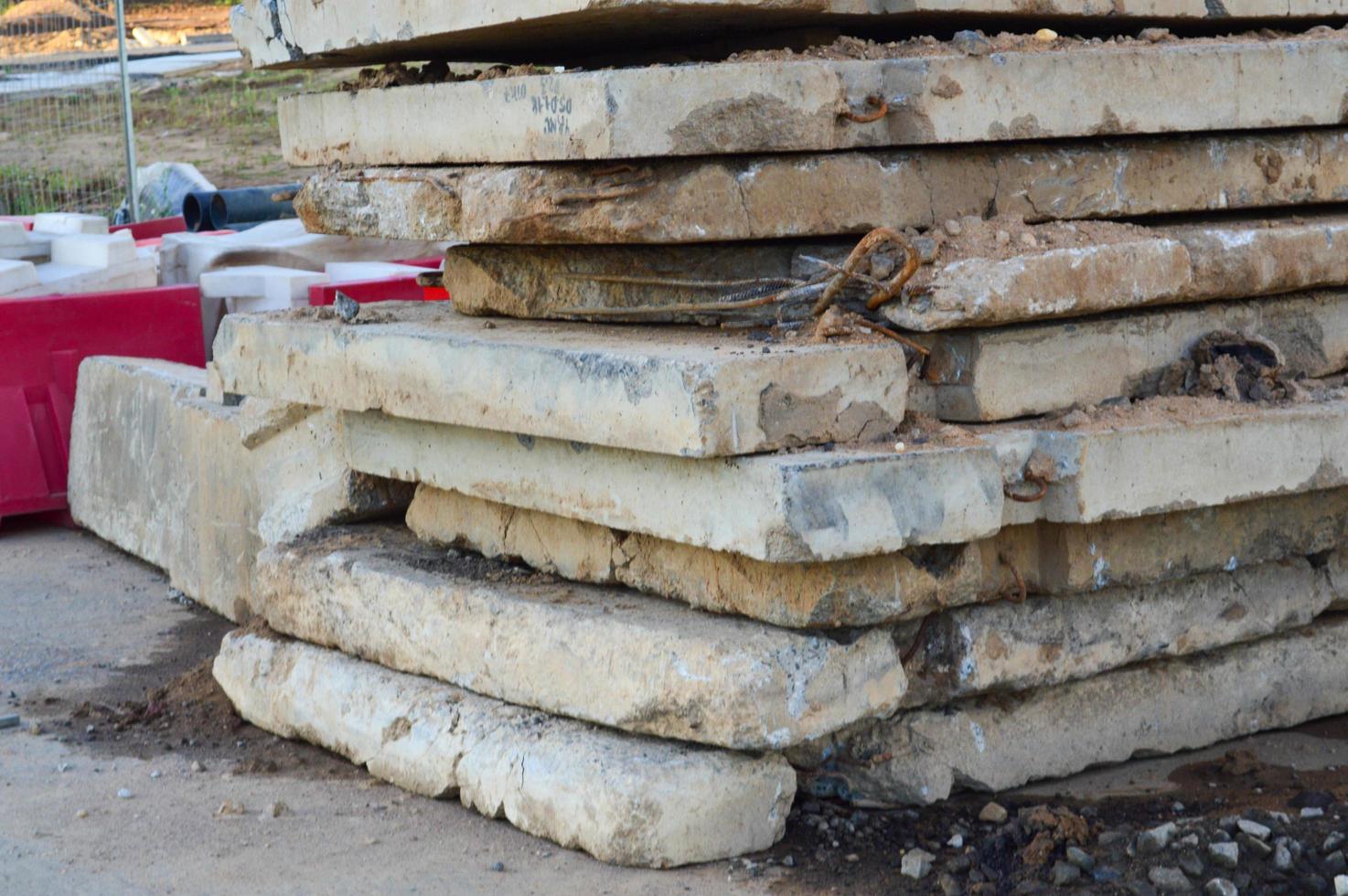 building concrete blocks with cracks lie on the construction site. plant construction. manufacturing of hazardous industries. blocks of concrete lie on brown ground photo