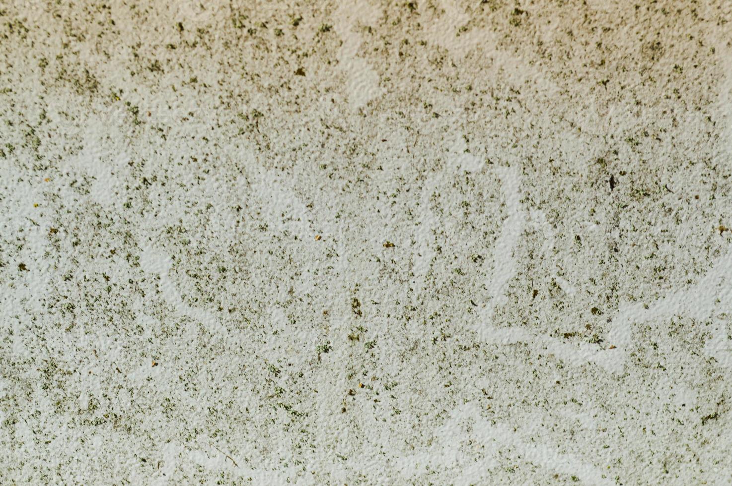 The texture of the stone concrete old shabby wall with cracks and chips with whitewashing and exfoliated plaster, putty. The background photo