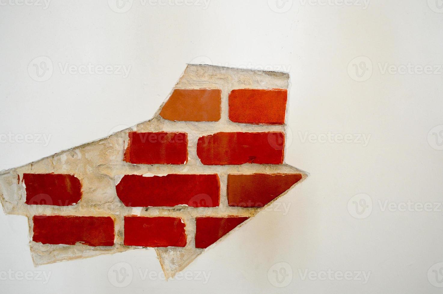 The texture of white stone concrete old battered red brick wall with seams with cracks and chips with whitewash and exfoliated plaster, putty. The background photo