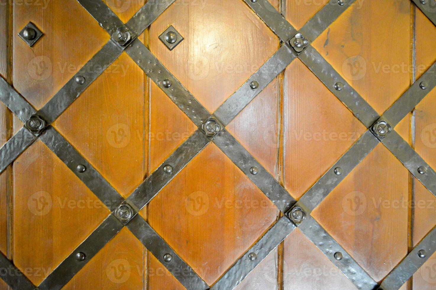 textura de la antigua puerta gruesa natural de madera resistente medieval antigua con remaches y patrones de clavos y cerraduras hechas de tablones de madera. el fondo foto