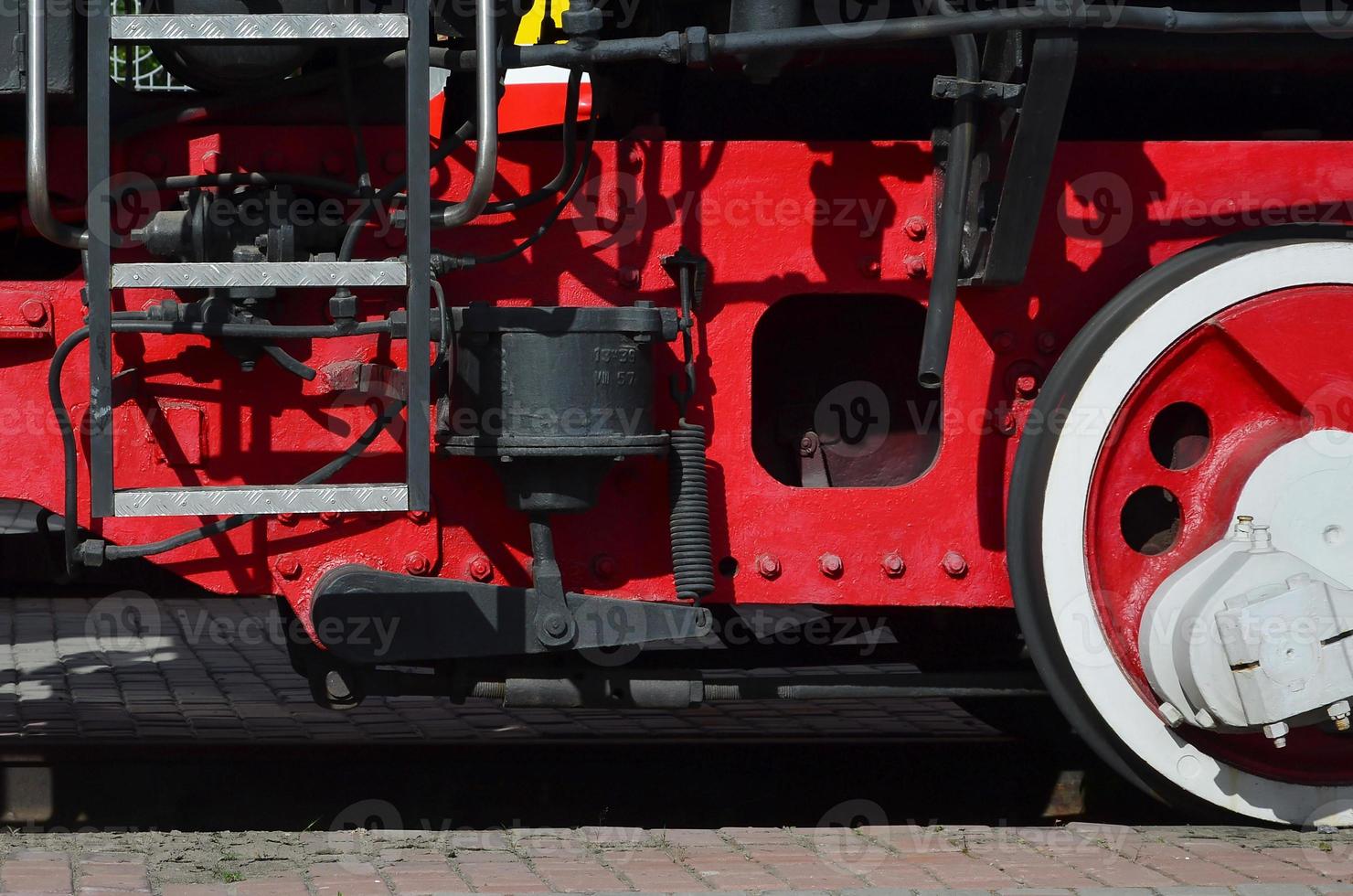 Wheels of the old black steam locomotive of Soviet times. The side of the locomotive with elements of the rotating technology of old trains photo