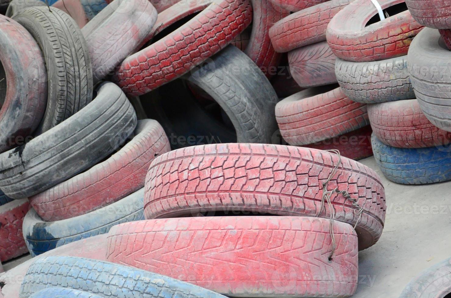 A picture of many old used tires left on a waste dump photo