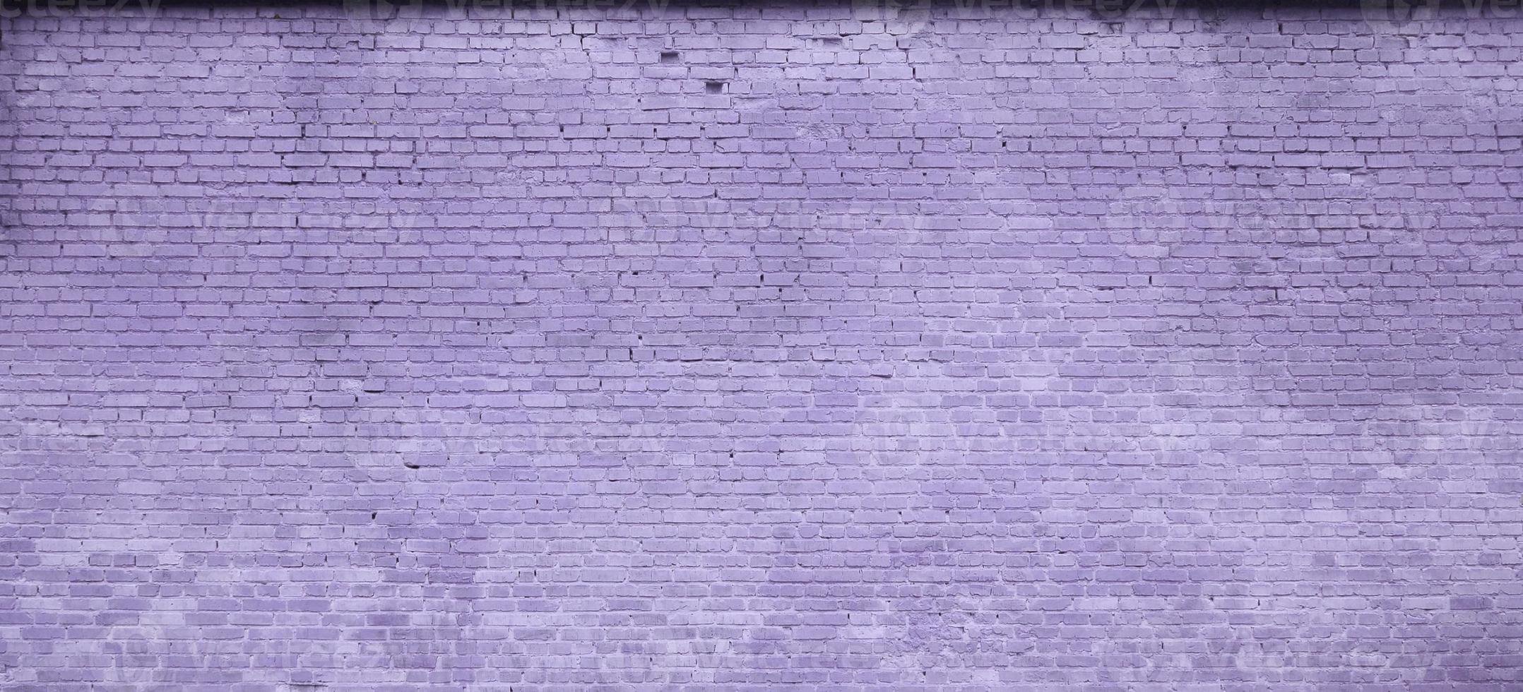 The texture of the brick wall of many rows of bricks painted in violet color photo