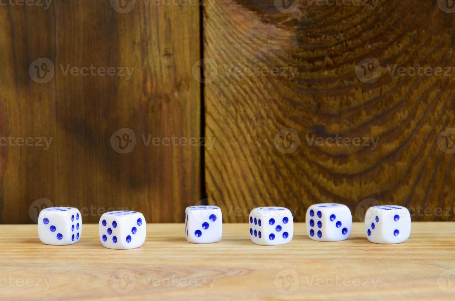 unos dados se encuentran en la superficie de madera natural. elementos para generar números del uno al seis en forma de puntos que se pintan en el lado de los cubos. el concepto de juego foto