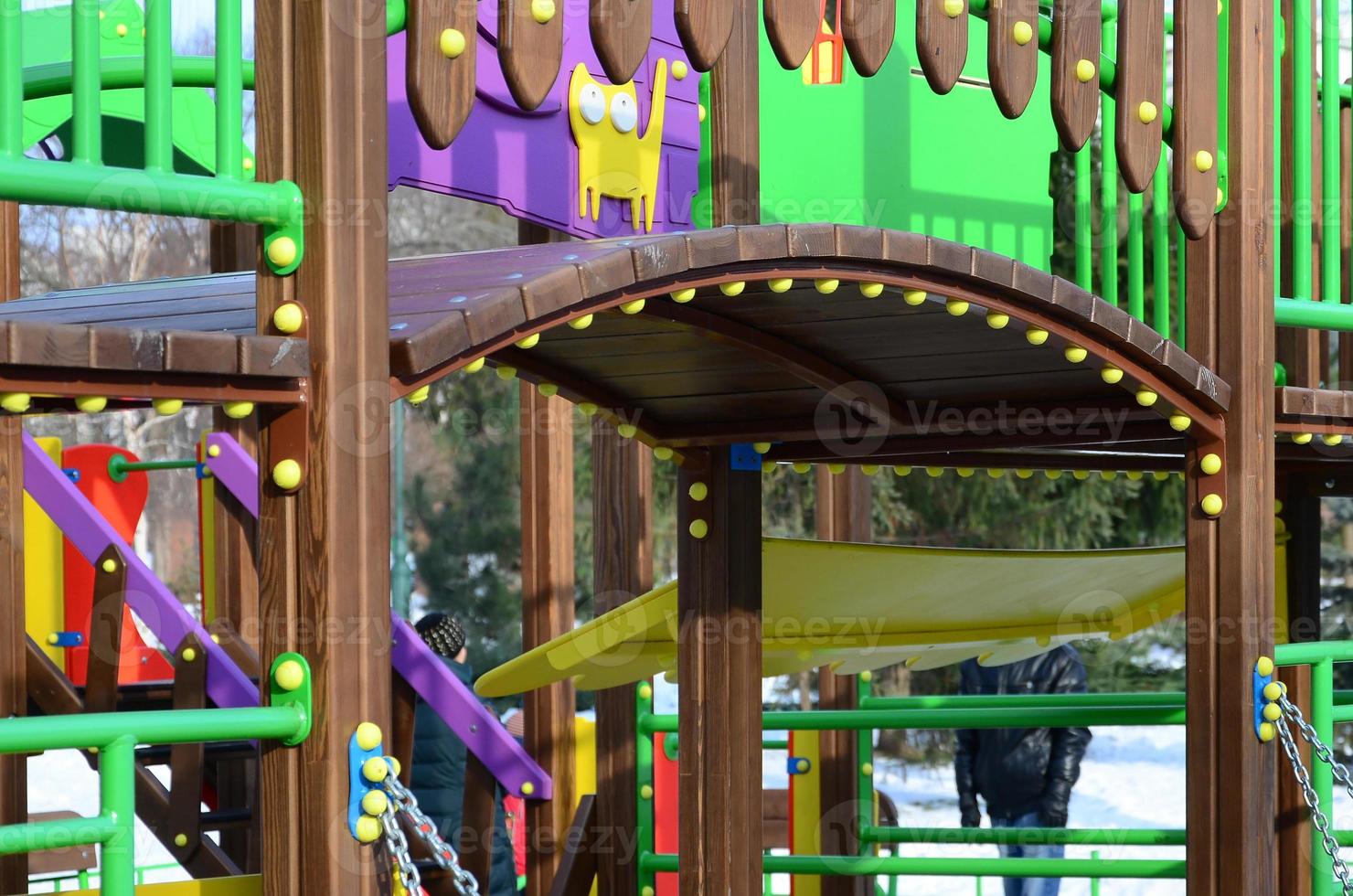 Fragment of a playground made of plastic and wood, painted in different colors photo