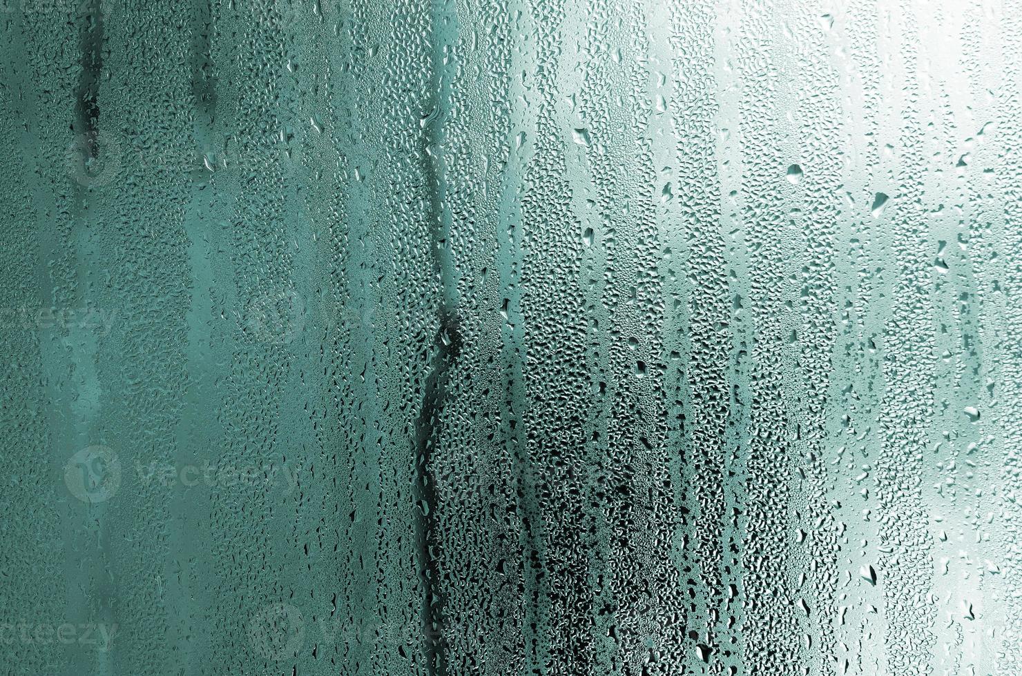 Texture of a drop of rain on a glass wet transparent background. Toned in turquoise color photo