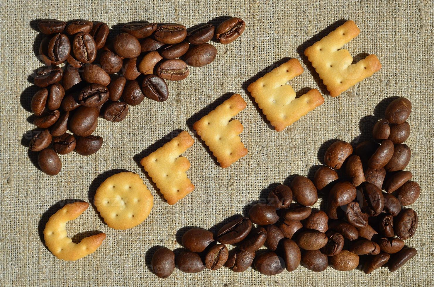 Coffee. The word from the edible letters lies on the gray canvas with coffee beans photo