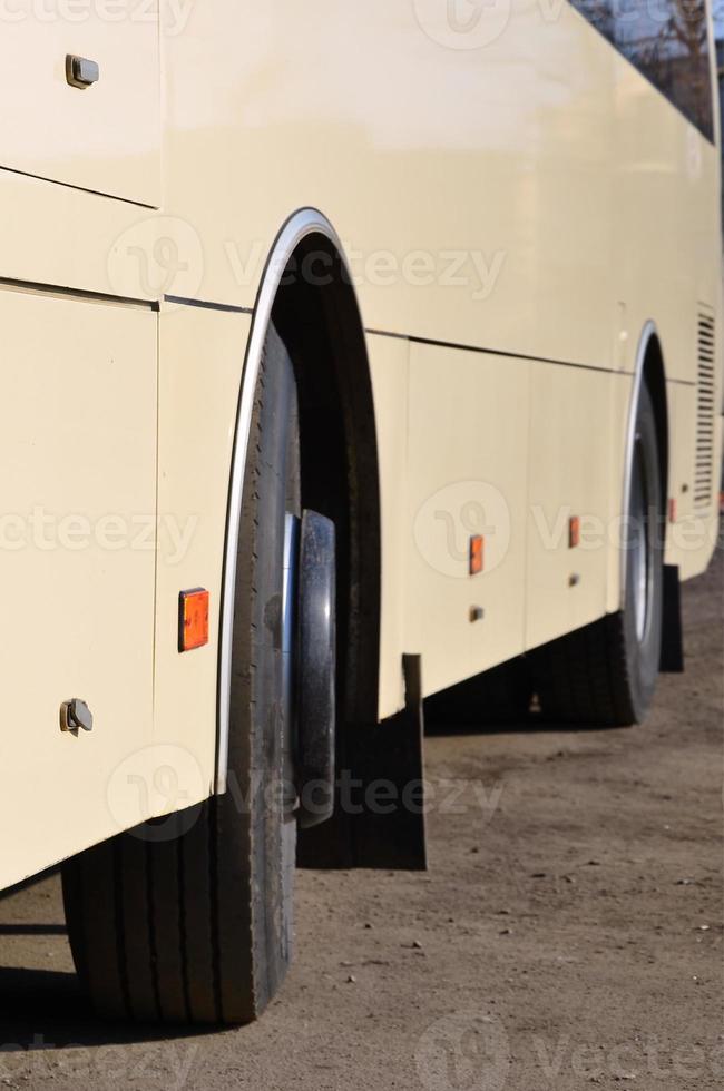 Photo of the hull of a large and long yellow bus. Close-up front view of a passenger vehicle for transportation and tourism