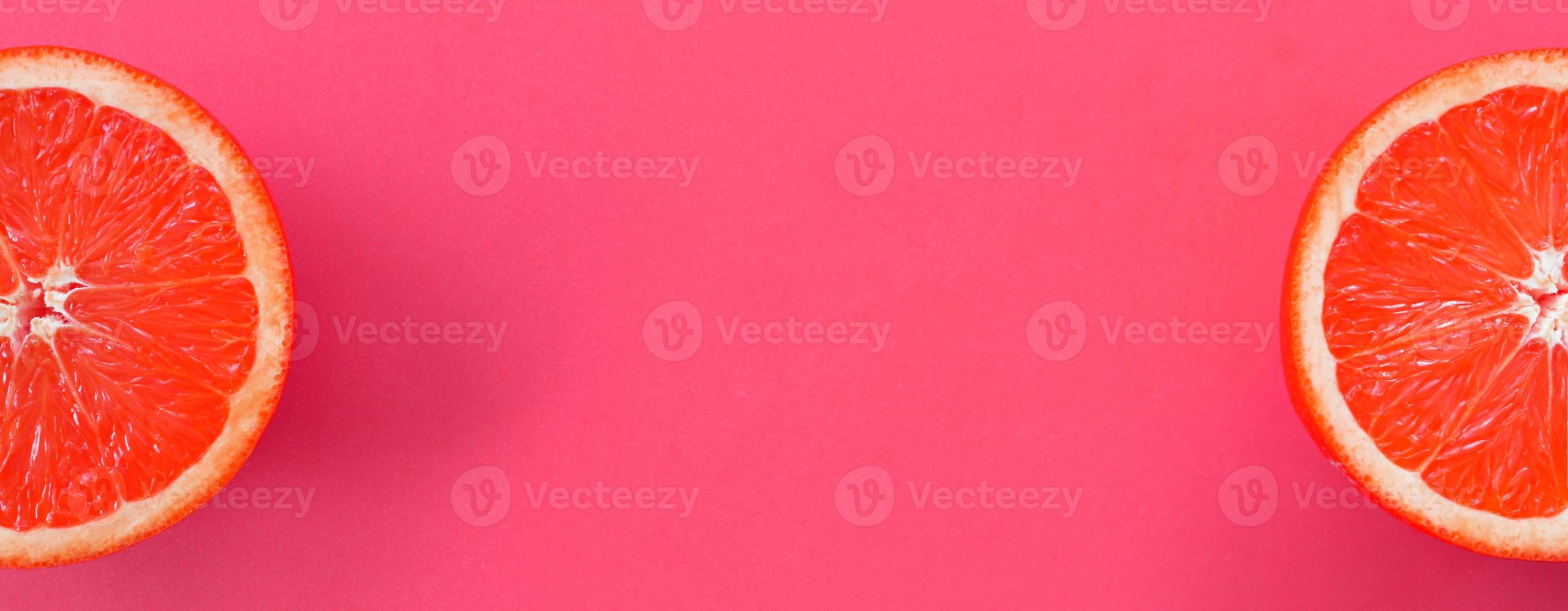 Top view of a several grapefruit slices on bright background in pink color. A saturated citrus texture image photo