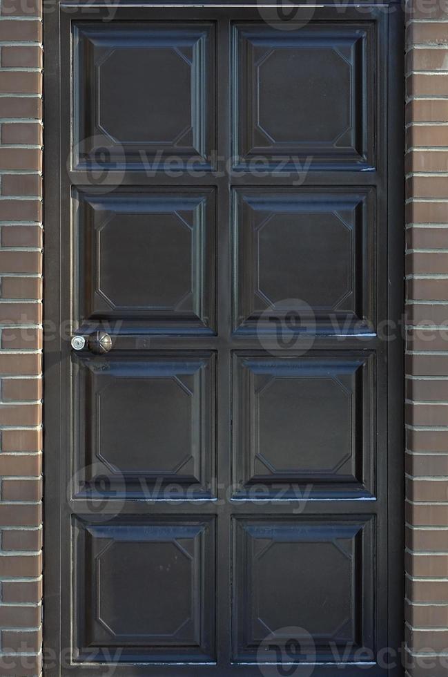 la textura de una puerta de metal pintada de una pared de ladrillo foto