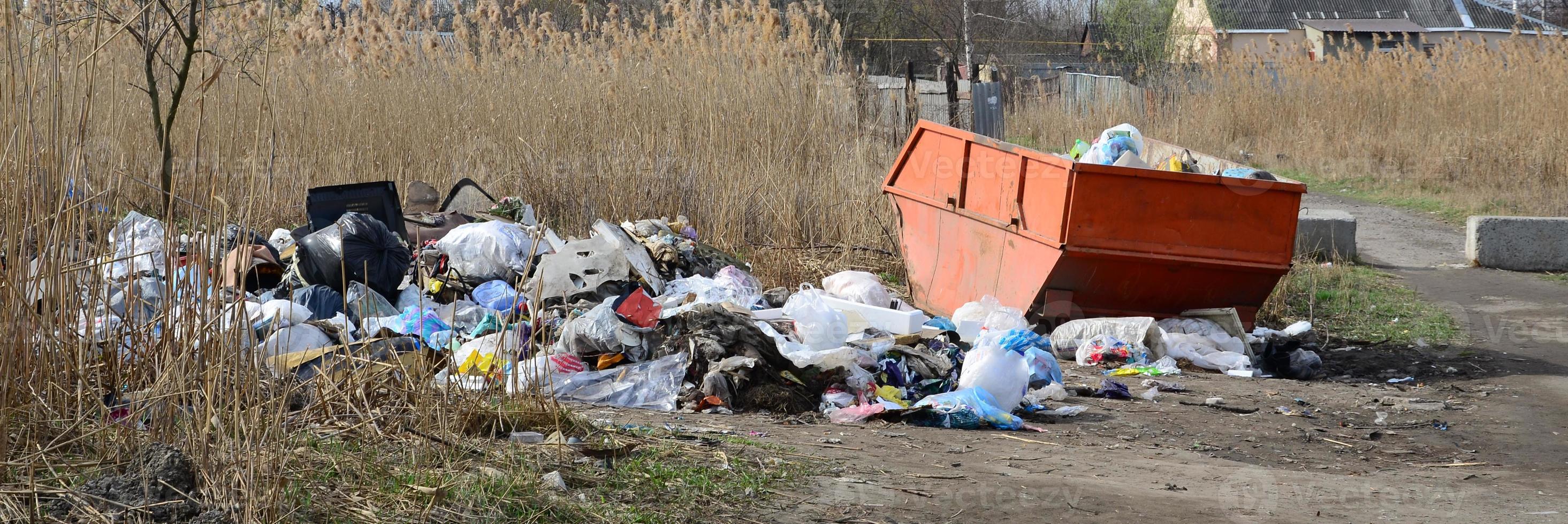 el bote de basura está lleno de basura y desechos. retiro intempestivo de basura en zonas pobladas foto