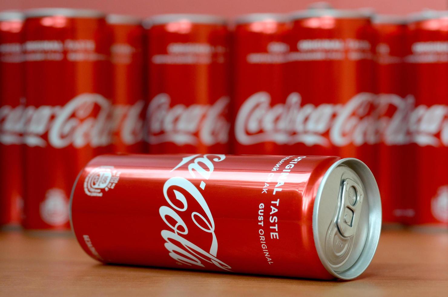 KHARKOV. UKRAINE - MAY 2, 2019 Coca-Cola logo printed on aluminium cans and placed on shopping mall table photo