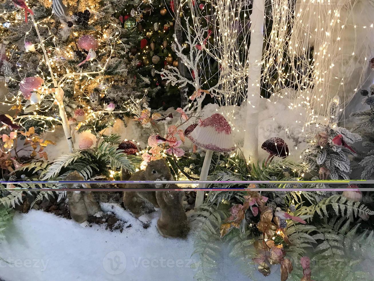 New Year's decorations for the shopping center. artificial Christmas trees covered with snow. in a snowdrift snow bears, squirrels and ferrets. next to them are tall multi-colored mushrooms photo