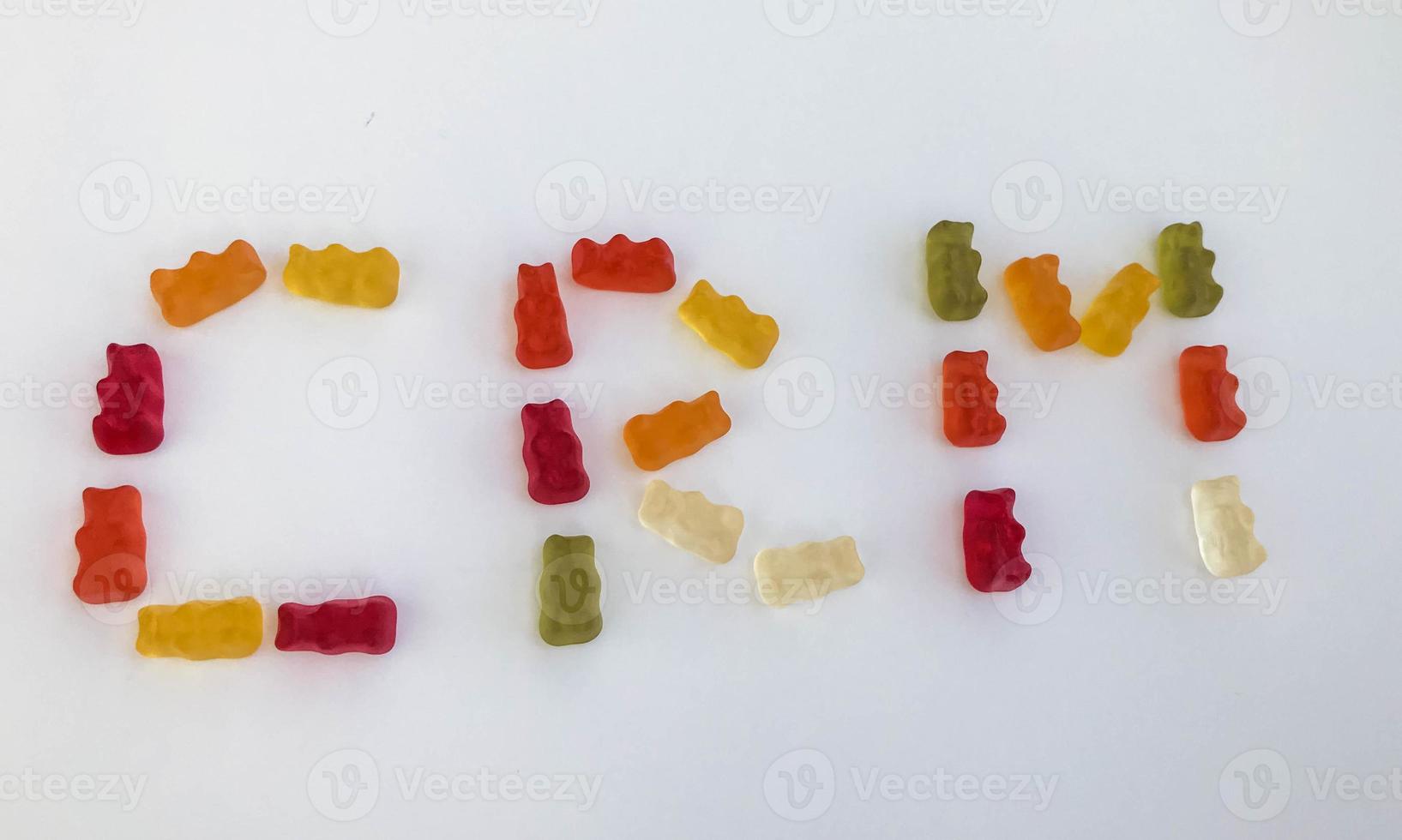 word from gummy gummy bears. edible letters C, R, M. vitamin and edible word. English alphabet. delicious appetizing dessert. bright bears on a white matte background photo