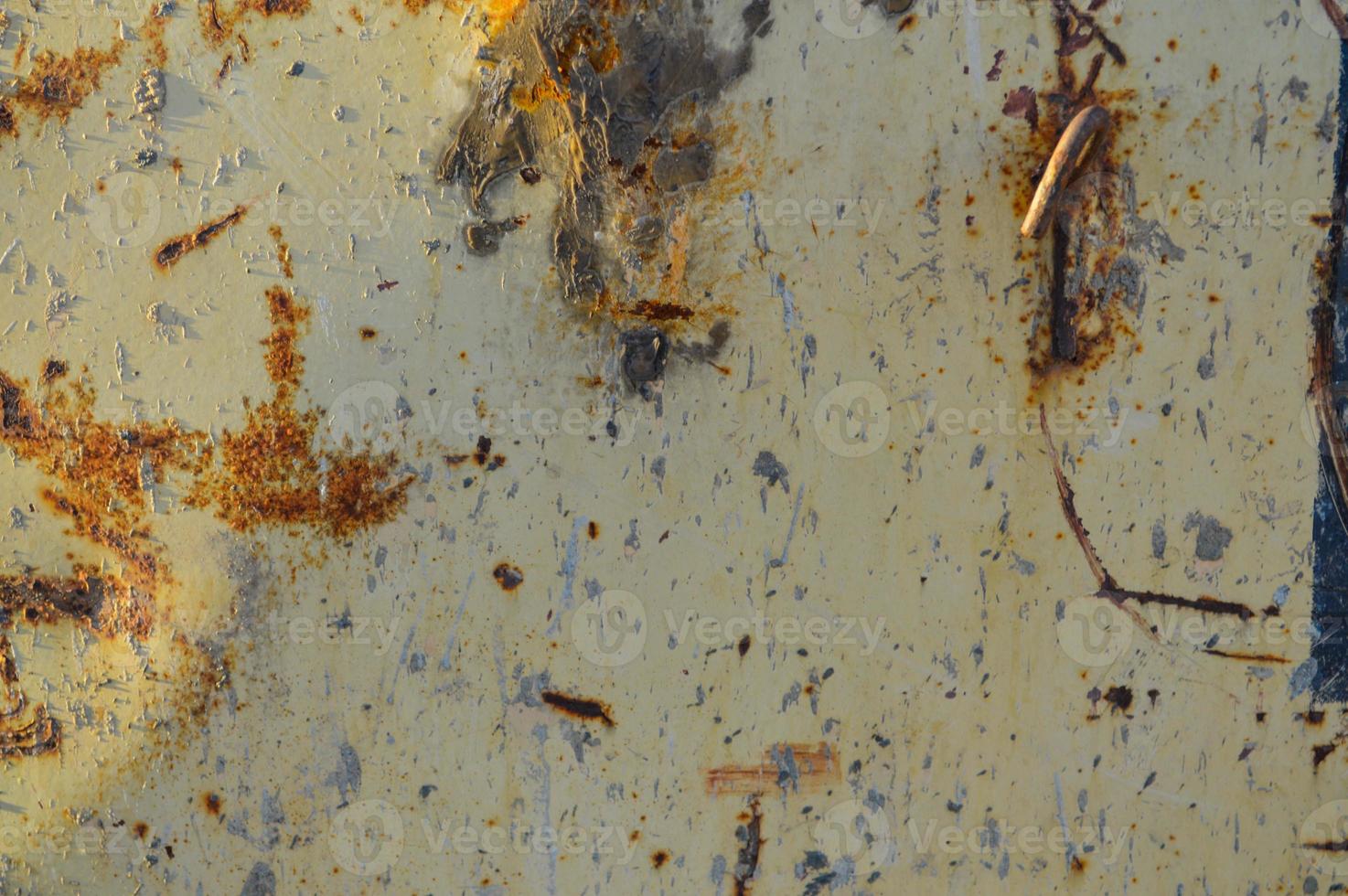 rusty, yellow with potholes texture. a piece of rusted metal with corrosion, the paint on it cracked from old age and precipitation. in the center there are indentations from damage photo