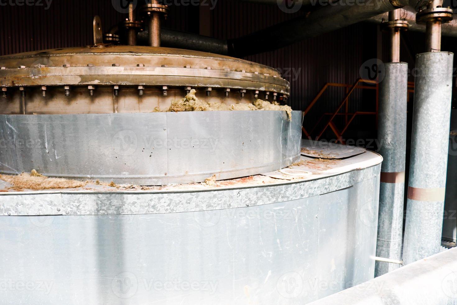 tapa metálica de acero inoxidable con pernos y espárragos, parte superior del intercambiador de calor de una columna de rectificación química con un tubo con bridas en una planta petroquímica de refinería industrial foto