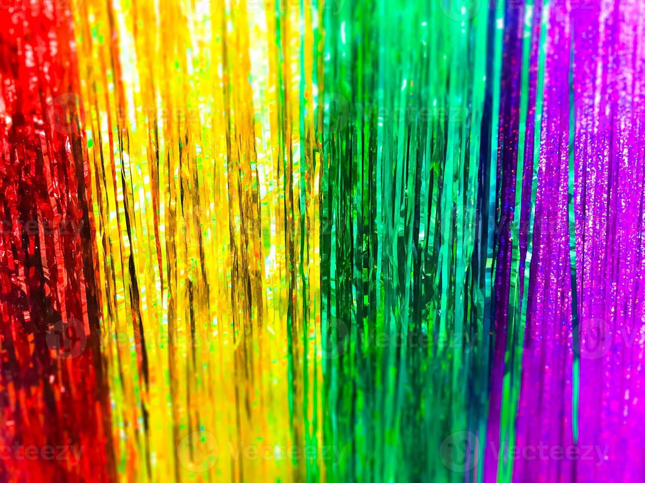 Festive multicolored rainbow shiny silver beautiful Christmas plastic garland sparkling for the New Year, Christmas-tree tinsel, festive decorated with a blur effect. Texture. Background photo