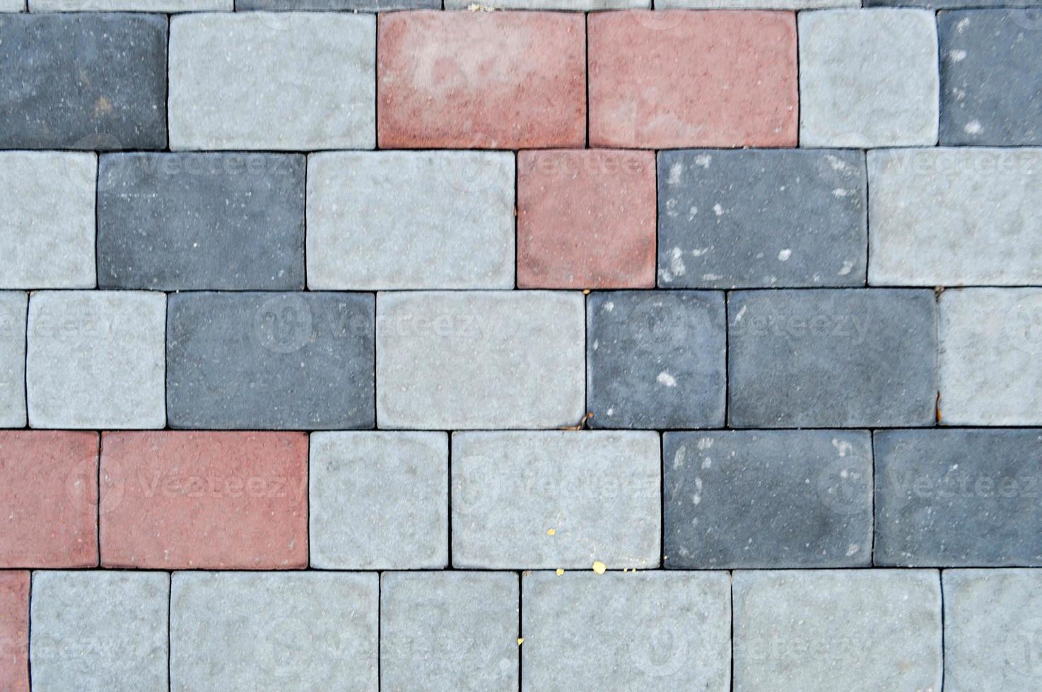 Texture of gray rectangular concrete stone paving slabs on the road with seams. The background photo