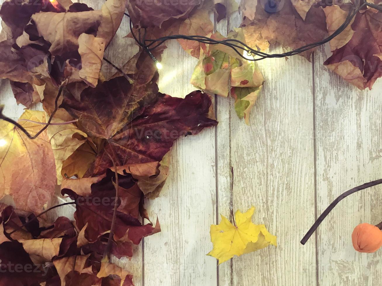 marco y hojas de otoño naturales de color marrón rojo amarillo, arce en el fondo de tablas de madera. el fondo. textura foto