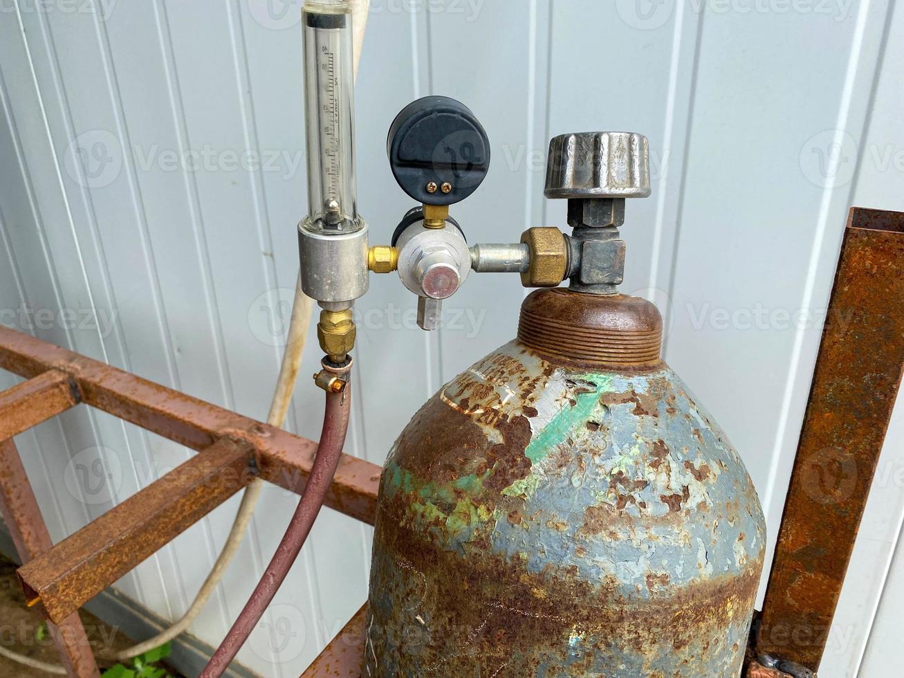 Reducer and pressure gauge for measuring pressure on an iron industrial gas cylinder in a factory photo