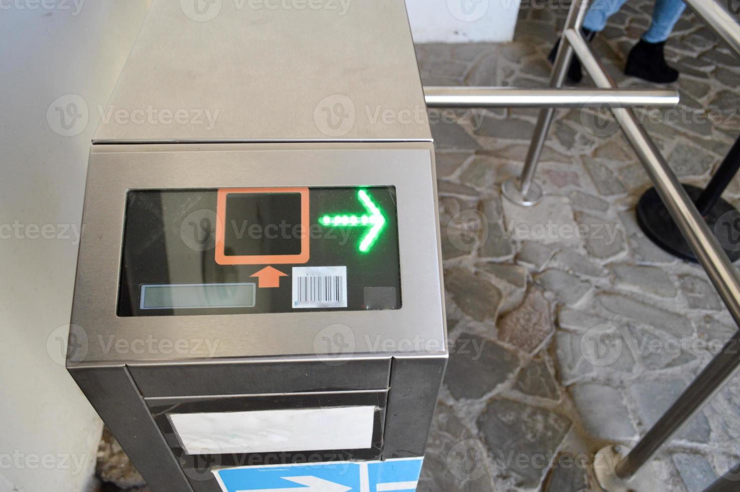 Modern metal automatic turnstile for passing people on plastic cards, passes. Electric checkpoint with a green arrow photo