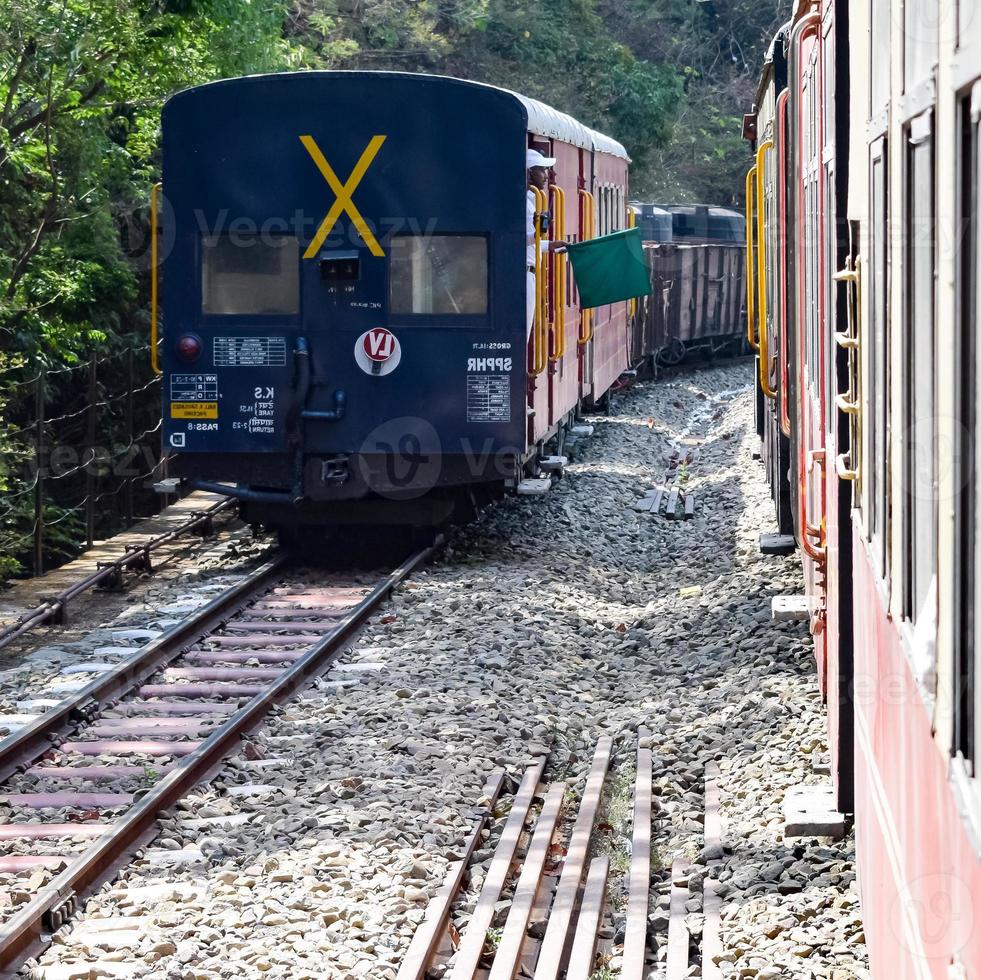 Toy Train moving on mountain slopes, beautiful view, one side mountain, one side valley moving on railway to the hill, among green natural forest. Toy train from Kalka to Shimla in India, Indian Train photo