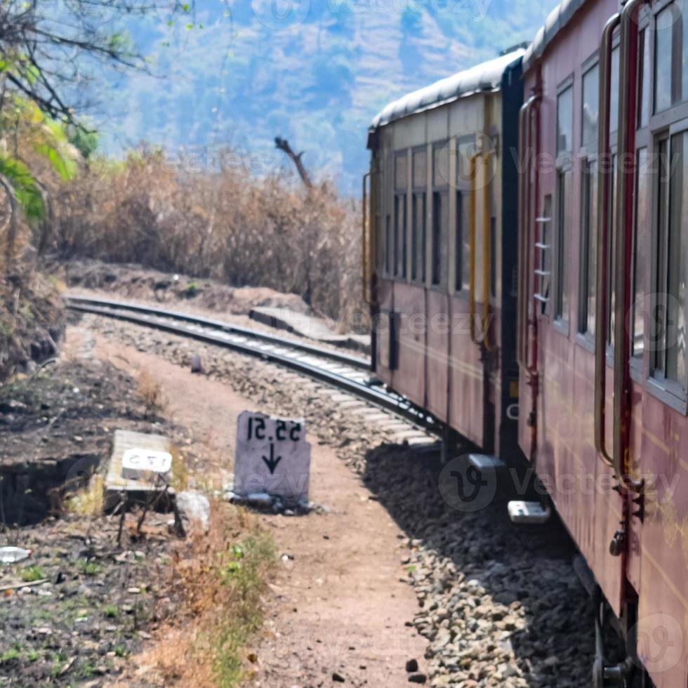 Toy Train moving on mountain slopes, beautiful view, one side mountain, one side valley moving on railway to the hill, among green natural forest. Toy train from Kalka to Shimla in India, Indian Train photo