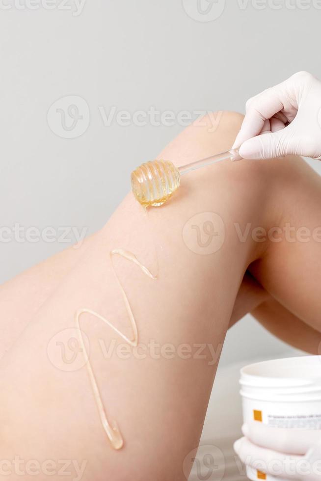 Wax flowing down on female leg photo