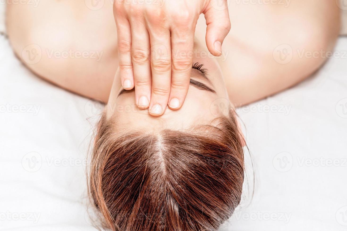 Forehead massage of woman. photo